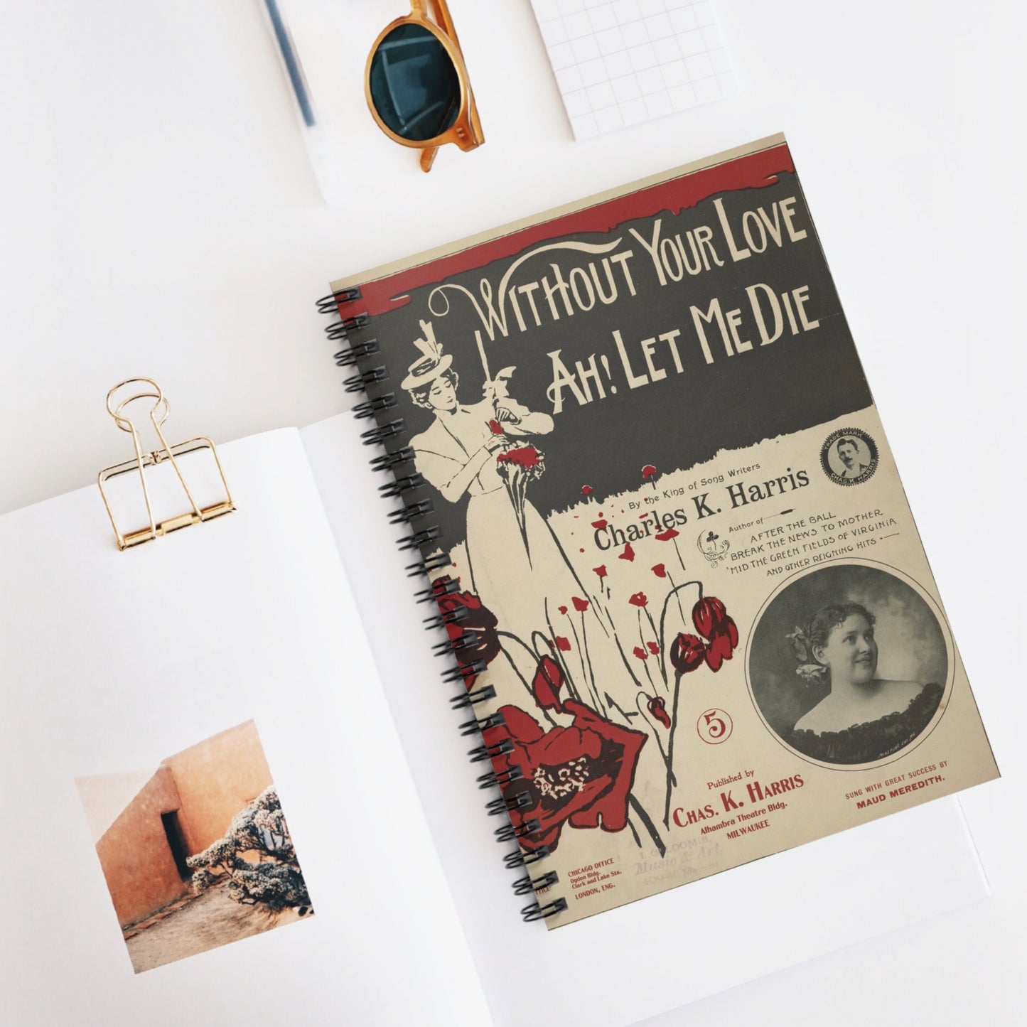 Vintage-style notebook with a cover design featuring text and images on a white surface.