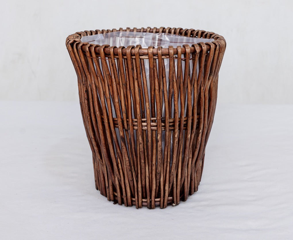 Wicker trash bin on a white background